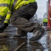 rabajador utilizando zapatilla de seguridad Palermo S3 en superficie mojada y resbaladiza durante trabajo industrial exterior