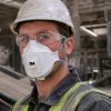 Operario utilizando mascarilla 3M Aura 9322+ FFP2 con válvula y gafas de protección en ambiente industrial con polvo