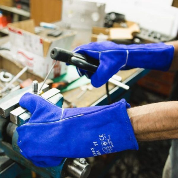 Operario utilizando guantes soldador NITREX S400A azules en trabajos de soldadura y manipulación metálica