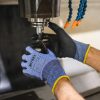 guante anticorte Nitrex 241PC18 manipulando pieza mecánica en maquinaria industrial