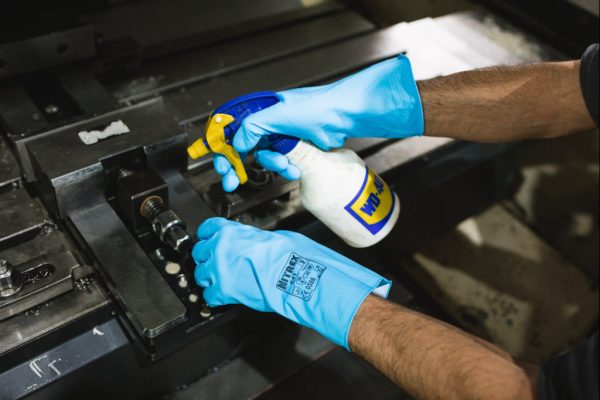 Operario utilizando guantes Nitrex 641 durante tareas de limpieza industrial con productos químicos