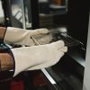 Operario utilizando guantes térmicos anti-calóricos NITREX para manipular bandejas calientes en horno industria
