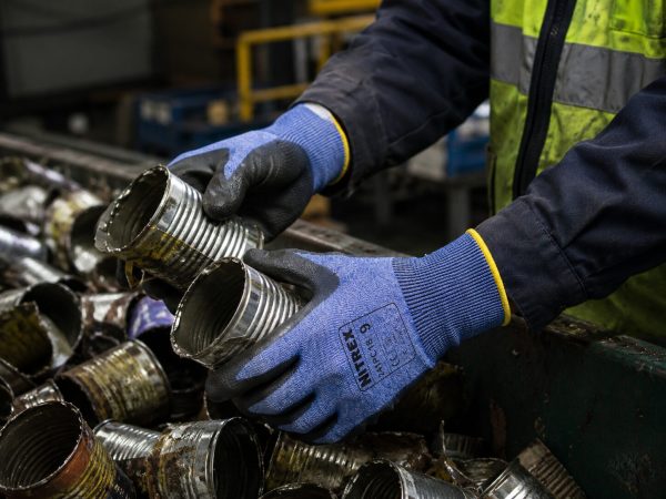trabajador utilizando guantes anticorte Nitrex 241PC18 manipulando piezas metálicas cortantes