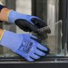 Trabajador utilizando guantes anticorte Nitrex 241NF manipulando cristal roto con alta protección al corte
