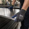 Operario utilizando guantes anticorte Nitrex 340RF para manipular chapas metálicas en entorno industrial
