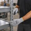Trabajador utilizando guantes Nitrex 245P para ensamblar estructuras y estanterías metálicas industriales