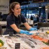 Trabajadora manipulando pescado fresco con guantes Nitrex 641 aptos para uso alimentario