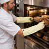 Operario utilizando el guante térmico largo NITREX 285L de Kevlar® para manipular bandejas calientes en horno industrial