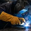 Soldador utilizando guantes NITREX S440R de serraje amarillo durante trabajos de soldadura industrial con chispas y altas temperaturas