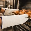 Guantes NITREX 280 de protección térmica NITREX manipulando bandeja de bollería caliente en horno de panadería