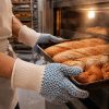 Guante NITREX 281 de algodón doble capa manipulando bandejas calientes de panadería con agarre antideslizante de nitrilo