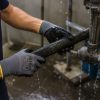 Operario manipulando una tubería húmeda en un entorno industrial con guantes nitrex 250