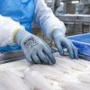 Guantes NITREX 250BU utilizados en procesamiento industrial de pescado.