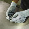 Operario manipulando piezas metálicas de precisión con guantes anticorte Nitrex 245P en entorno industrial