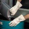 Guante industrial Nitrex 420BL de color blanco en pleno trasvase de líquidos desde una garrafa.