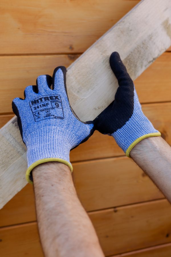 Operario sujetando piezas de madera con guantes anticorte Nitrex 241NF resistentes al desgaste y cortes