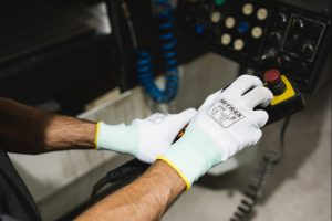 guante Nitrex 290 blanco manipulando panel de control industrial