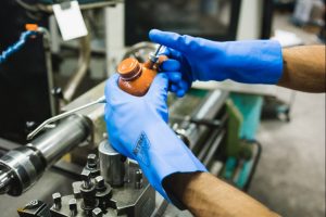 Trabajador utilizando guantes Nitrex 645 en tareas de mantenimiento y manipulación industrial