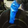 Trabajador usando guante largo impermeable NITREX 314LNIT azul para manipular líquidos y recipientes en entorno industrial.